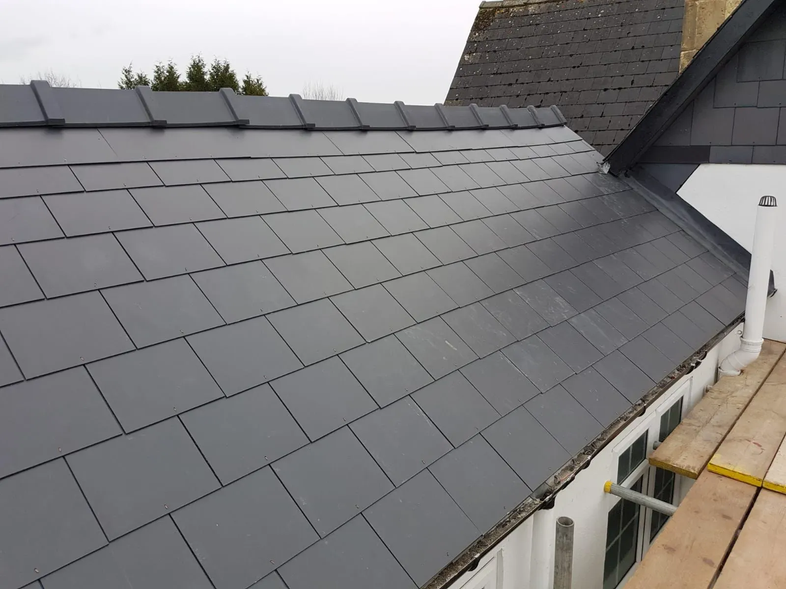 A newly installed grey tiled roof with a dry ridge system in Gloucestershire.