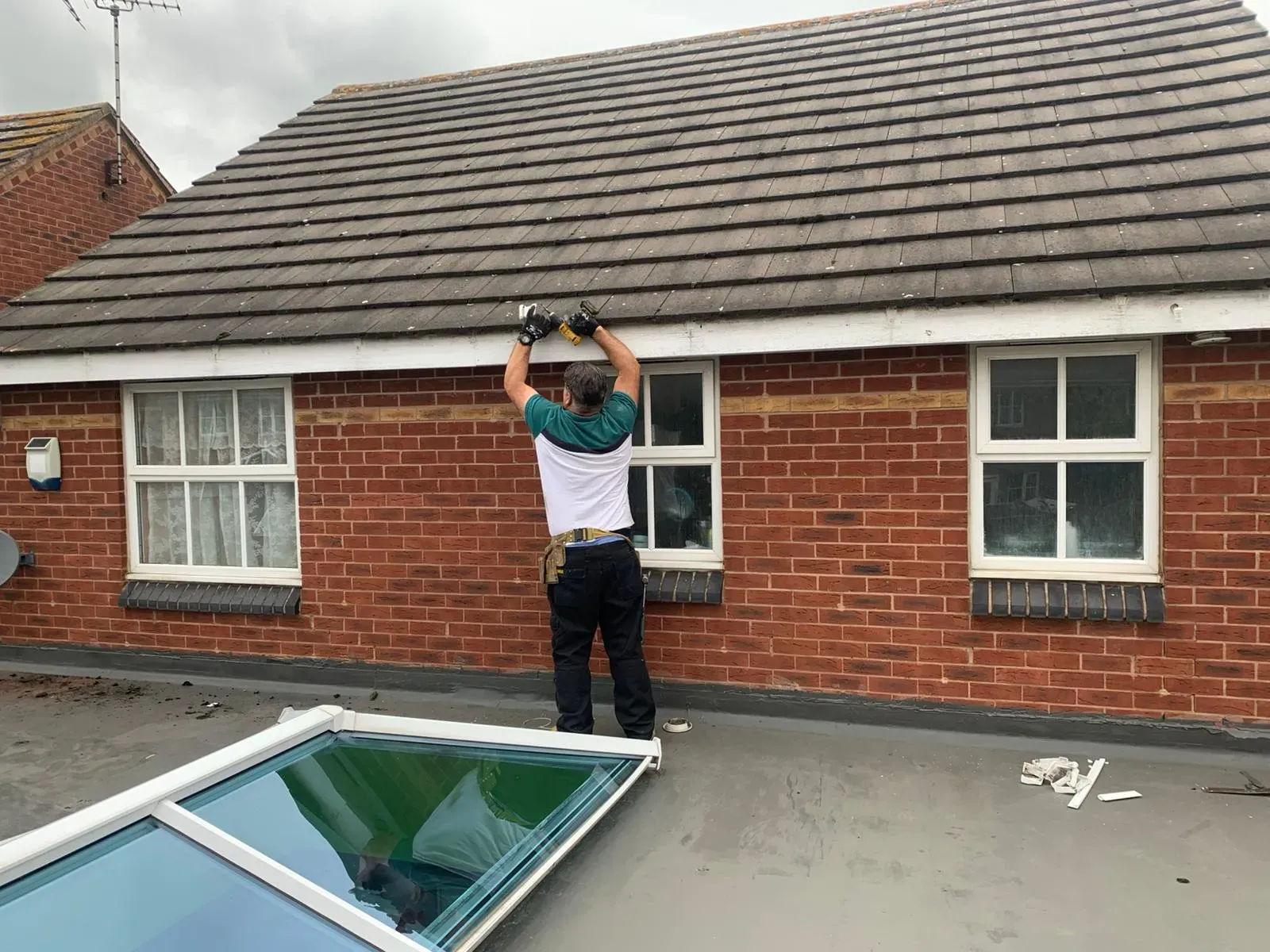 A roofer working on uPVC fascias and soffits in Gloucestershire